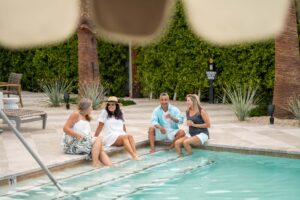 Adults floating in an adults-only pool at a Palm Springs boutique hotel on a summer afternoon